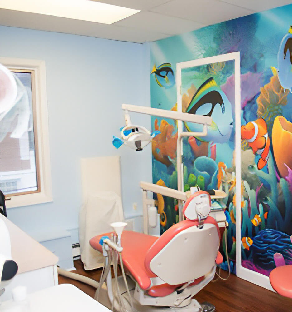 Pediatric dental treatment room with coral-colored dental chair and vibrant underwater mural featuring tropical fish and coral reef scenes on the wall